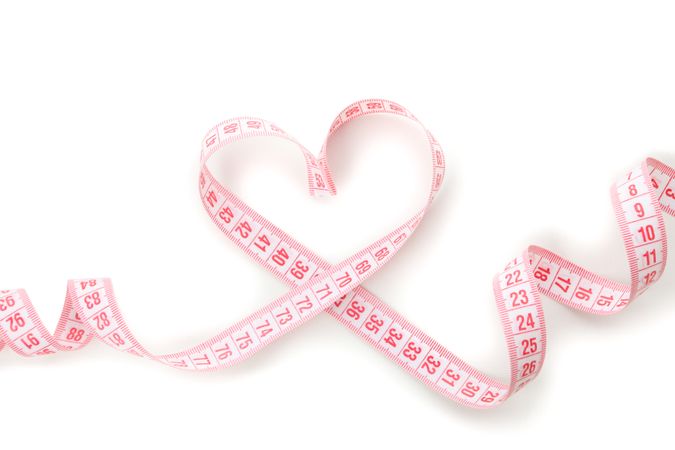 Measuring tape in the form of heart isolated on blank background