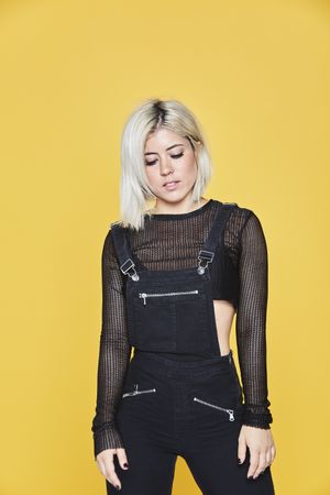 female in dark outfit in yellow studio