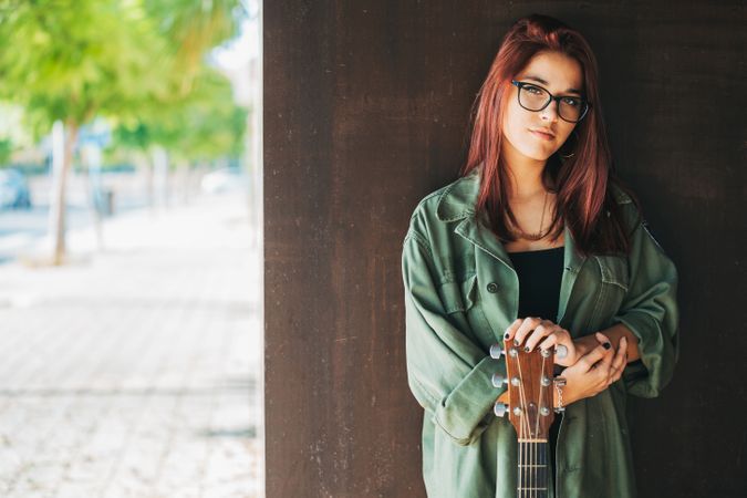 Woman in glasses leaning on wall