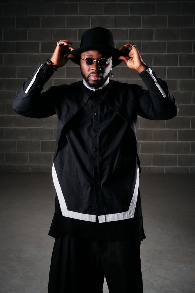 Stylish man standing in dark room