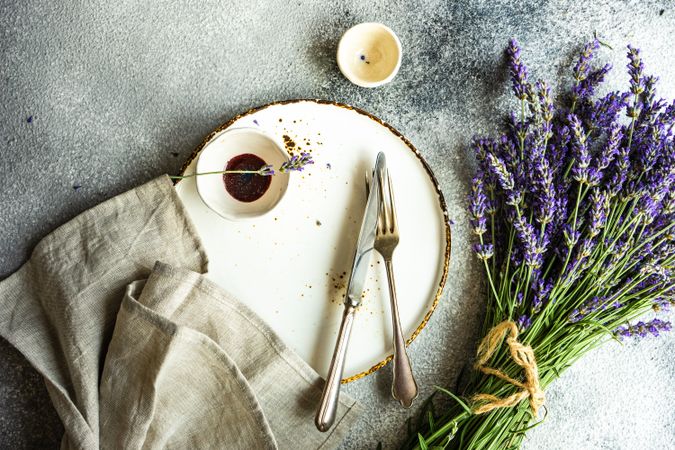 Top view of table setting with vinegar, bunch of lavender and silverware