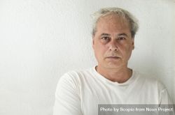 Portrait of disappointed middle aged man in light shirt against light wall 4dWZQ5