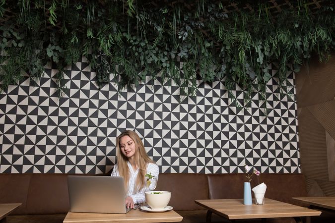 Young woman using laptop in cafe