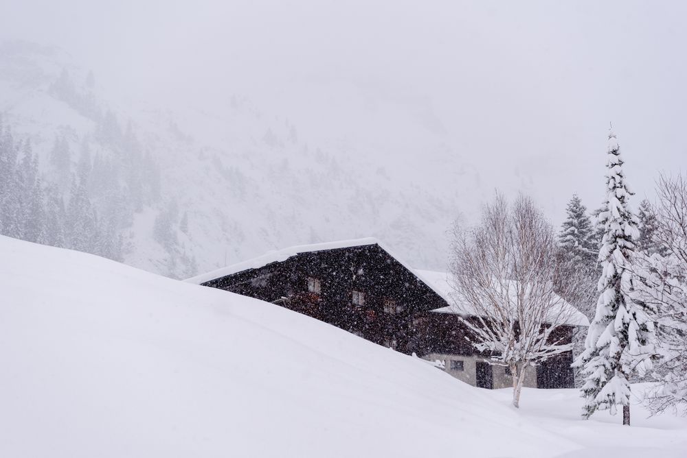 Alpine cabin on a blizzard surrounded by deep snow in the Bavarian Alps, Germany