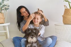 Mother doing hairstyle to positive boy