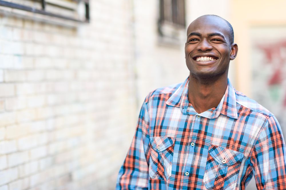 Happy male in plaid shirt walking down alley way