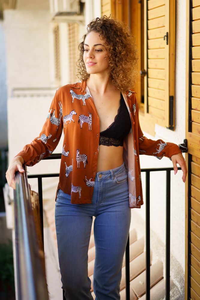 Relaxed woman standing on her balcony in the morning