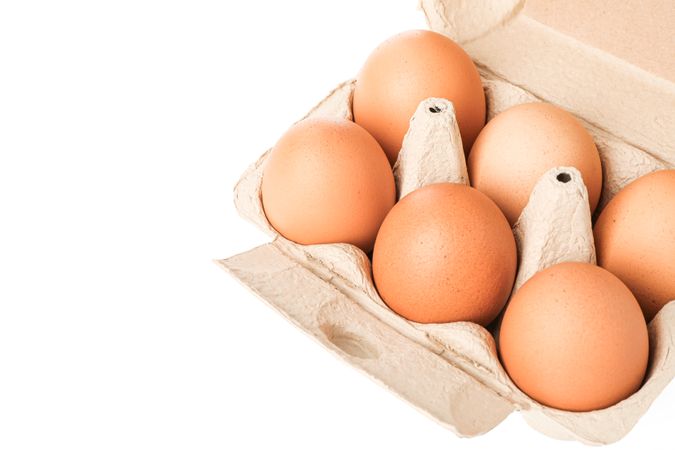 Brown chicken eggs in carton box isolated on light background