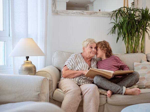 Boy whispering to grandma