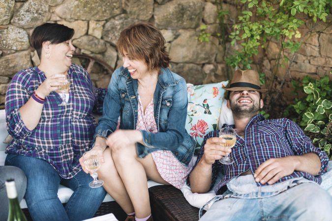 Portrait of happy people sitting together and laughing while enjoying a party with wine