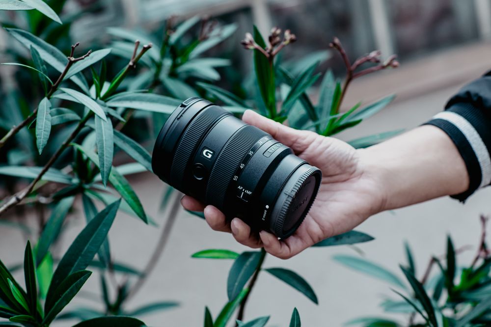 Person holding camera lens