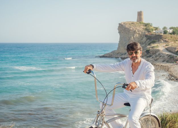 Man cycling on sandy beach hill