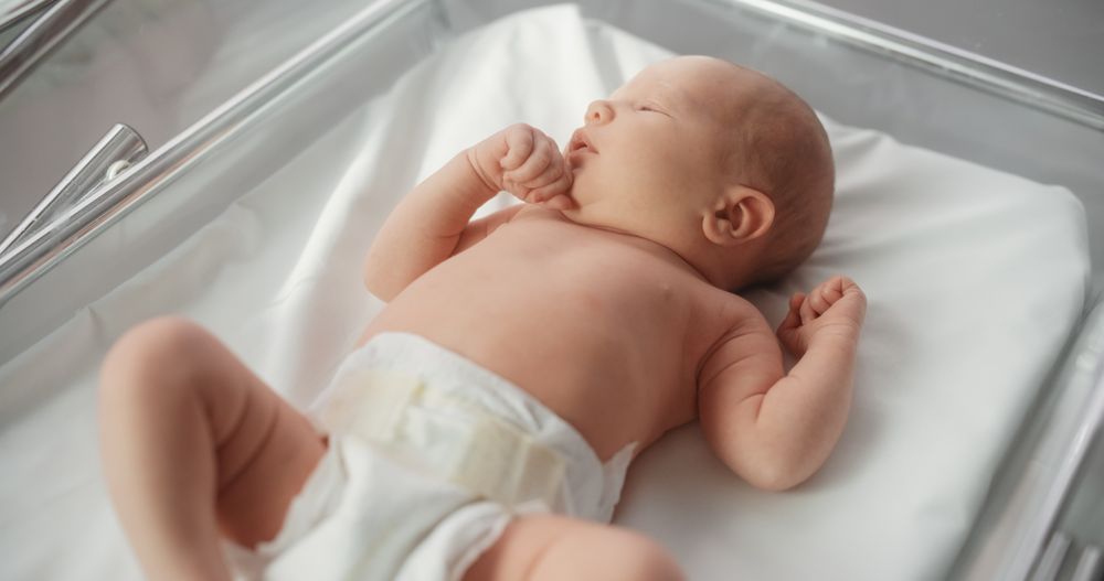 Adorable Small Newborn Child Lying in Hospital Bed in a Nursery Clinic.