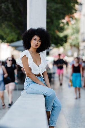 Black female sitting on concrete parapet