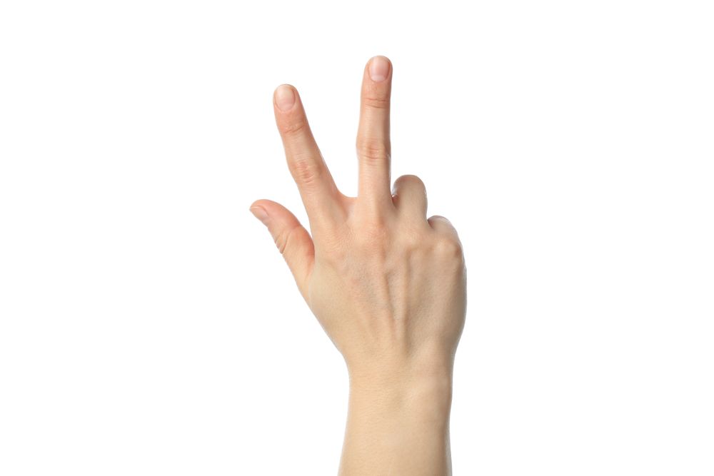 Woman hand showing three fingers, isolated on plain background