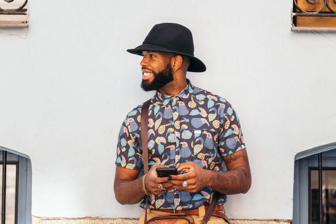 Stylish Black man using smartphone outdoors in the city