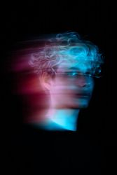 Blurry portrait of blonde young man with uv hair dye in a studio 4jz7x4