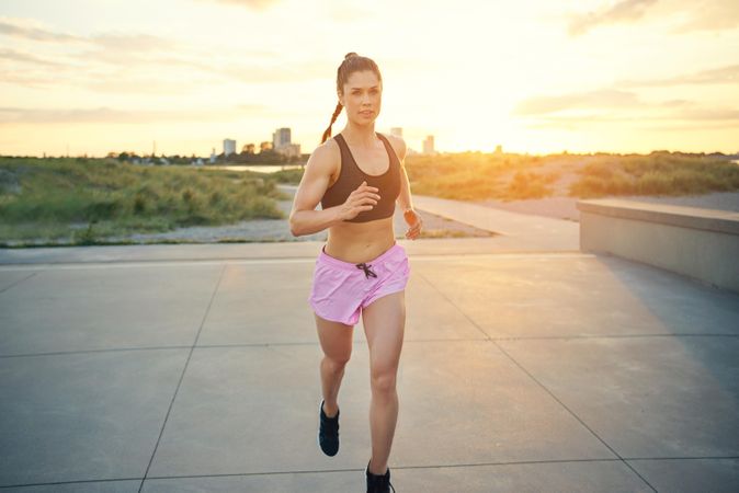 Woman in pink shorts jogging in morning light