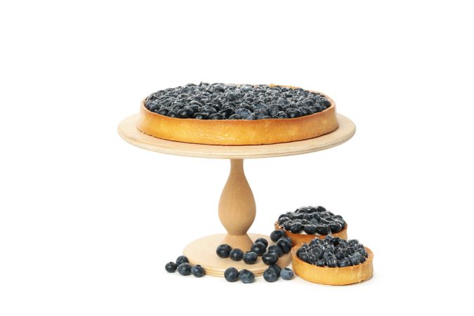 Wooden board with blueberry pie isolated on light background