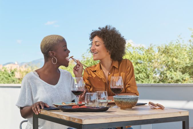 Cheerful women having lunch together in outdoor cafe
