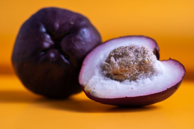 two Syzygium malaccense or known as jambu jamaika fruits are on a yellow background