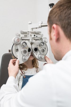 Optician testing a girl's eyes