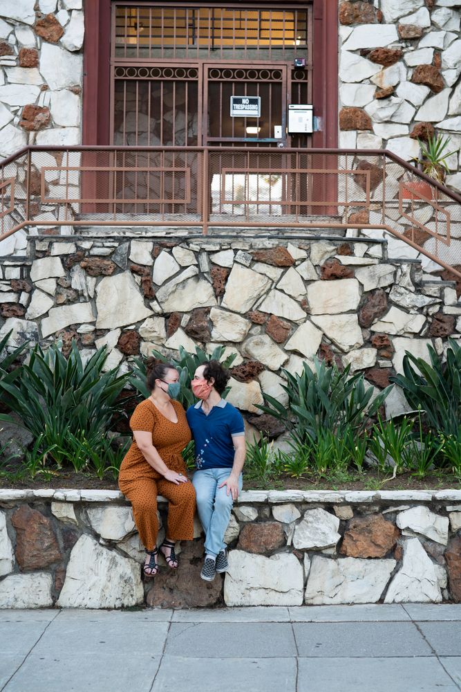 Happy couple sitting on stone wall together outside in the evening