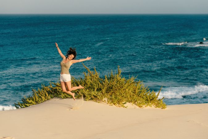 Active woman in white shorts walking sandy beach