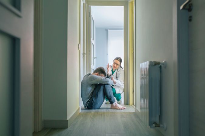 Female doctor trying to help male patient