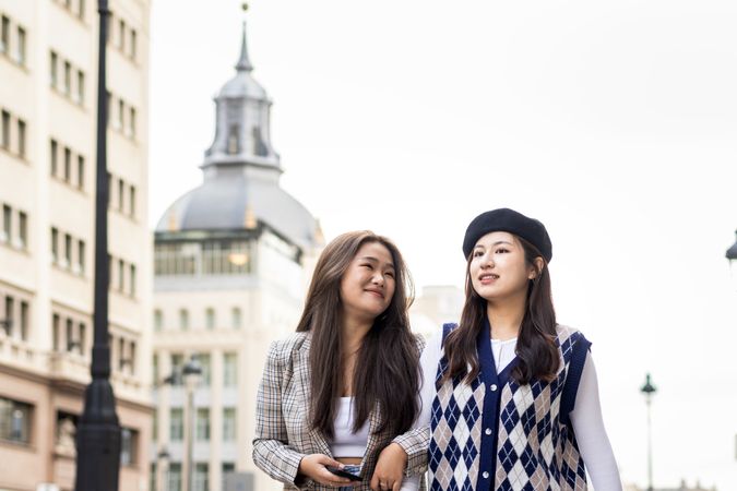 Asian young female friends walking on the street in the city