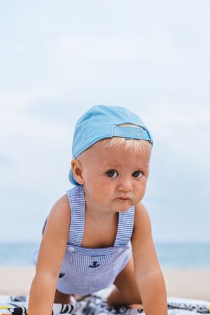 Portrait of a baby boy with his cap on the beach