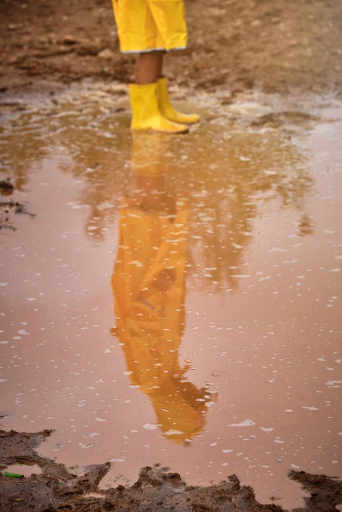 Crop child standing in puddle