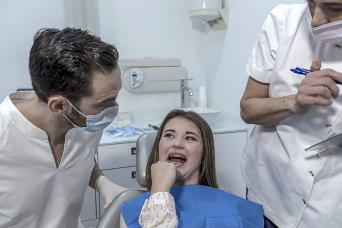 Teen female with toothache pain sitting to dental chair