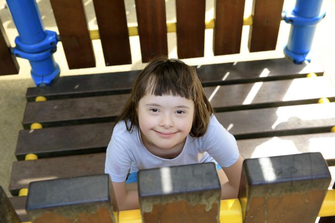 Happy child sitting in an outdoor playset