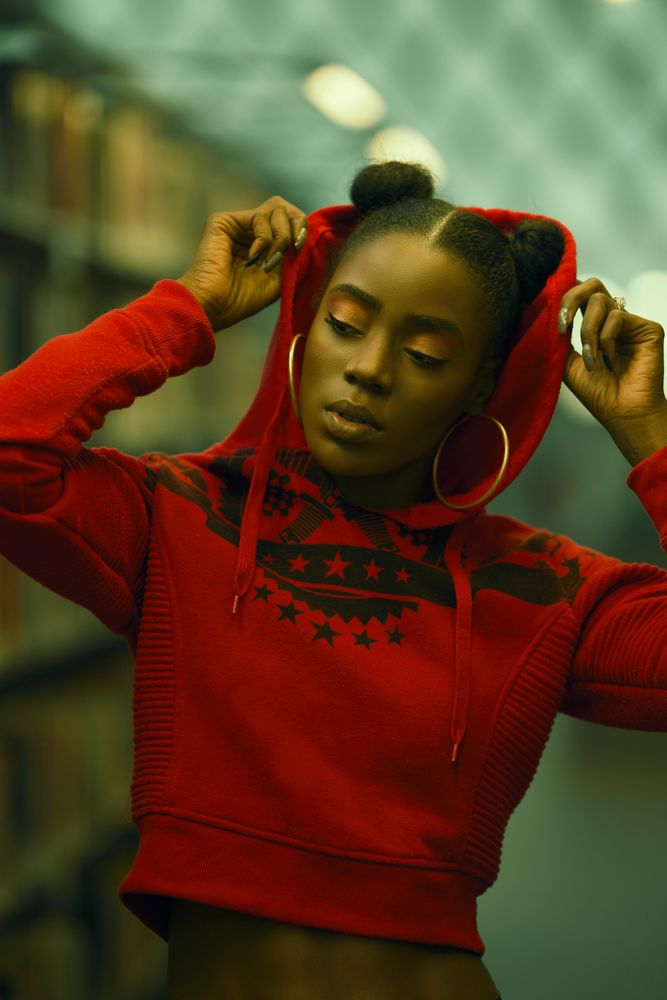 Portrait of woman in red crop-top hoodie in focus