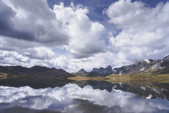 Cloudy sky over calm lake and mountains
