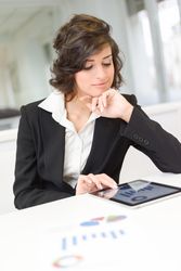 Female in business attire going over data and charts in a bright office