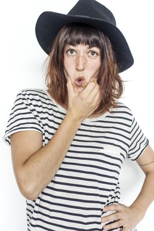 Female in striped shirt and felt hat holding mouth making funny face