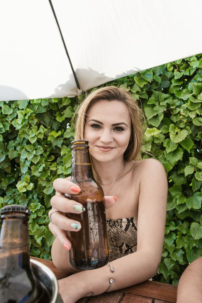 Blonde woman drinking beer on a terrace