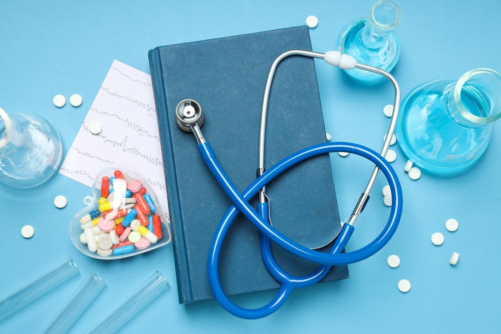 Medical literature - book and doctors accessories on blue background