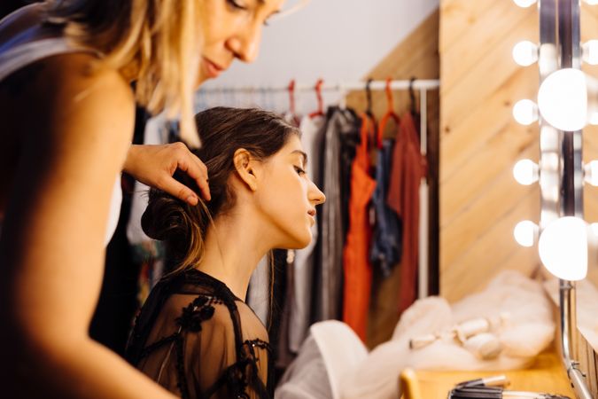 Makeup artist doing makeup for young female artist