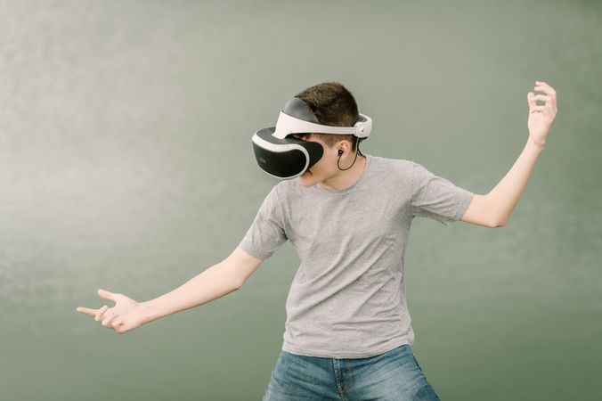Young teenager with virtual reality glasses outdoors