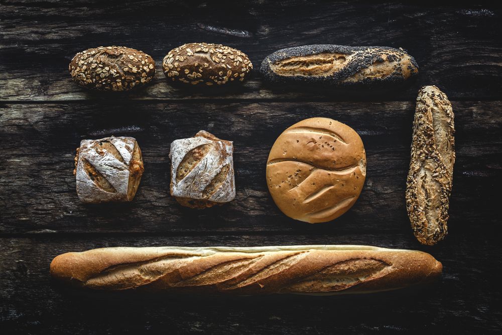 Assorted gold homemade bread on dark wood background