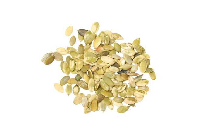 Fall season food - pumpkin seeds, isolated on light background