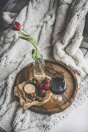 Wine, snacks and glasses on tray with with one flower, top view