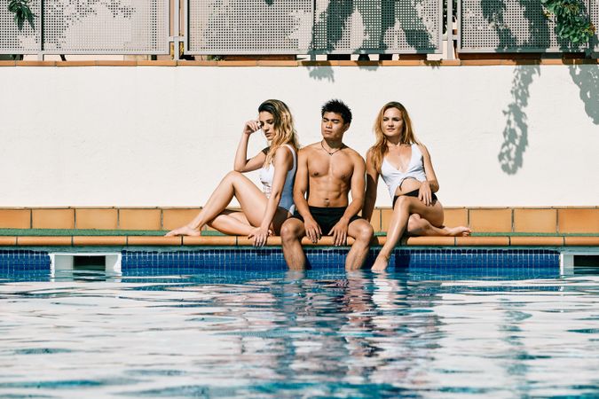 a group of young models by the pool in a summer day