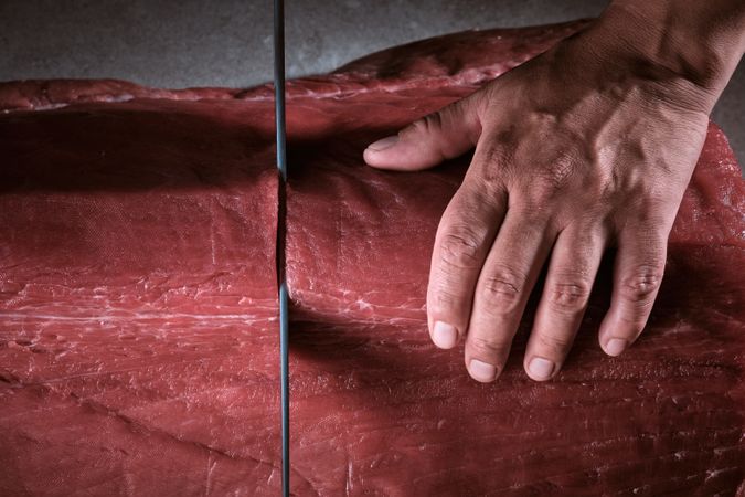 Male hands of a chef cutting a delicious loin of fresh bluefin t