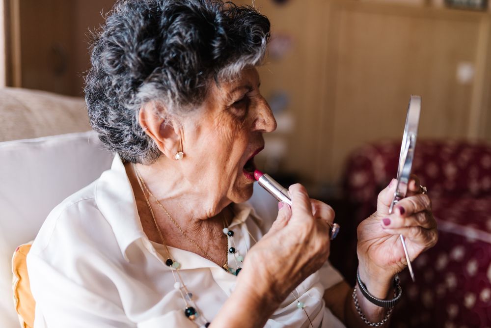 Mature woman doing lips makeup at home
