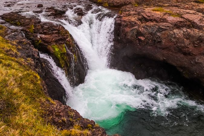 Waterfall with a green pool below it