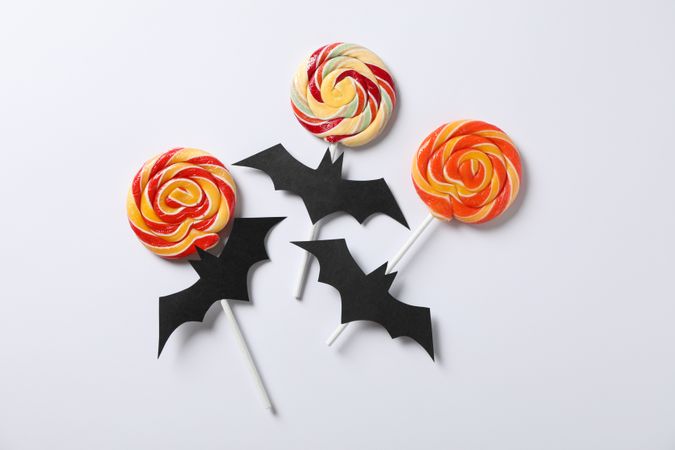 Candy and decorative bats on plain background, copy space